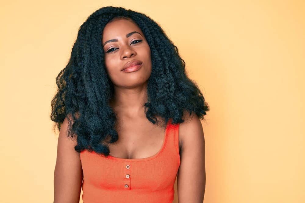 A lady, after trying on several curly wigs, decided to wear her natural curls styled with regular hair products.