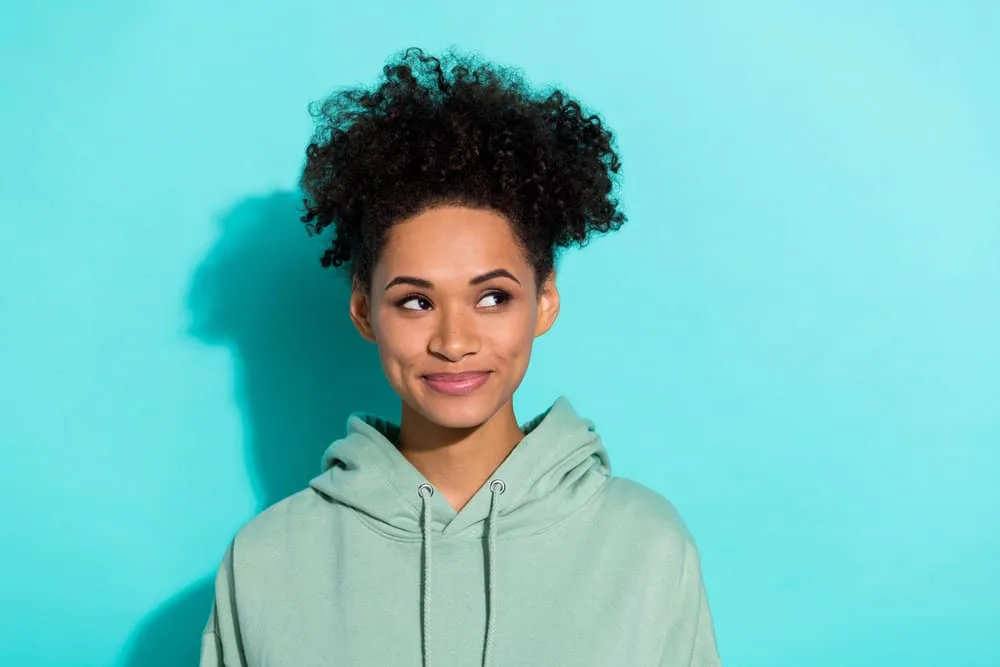 Does Sulfur8 Grow Hair? Help Dandruff? Does It Really Work? 8 Cute young girl using coconut oil on her African American hair, making the hairstyling process easier.