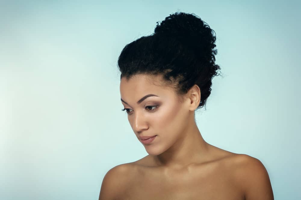 Young female with wet hair used that following products to detangle hair on her neck, coconut oil and  argan oil.