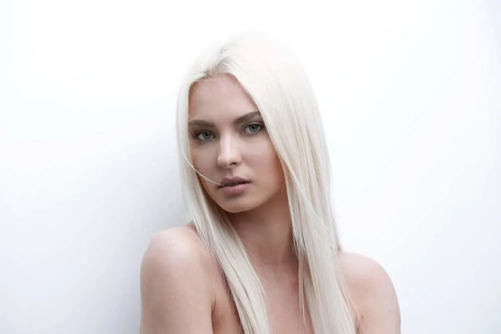 How to Get Platinum Blonde Hair from Golden Blonde at Home 4 A lady with light blonde hair is treated with purple toner, which gives it a violet hue in the sunlight.