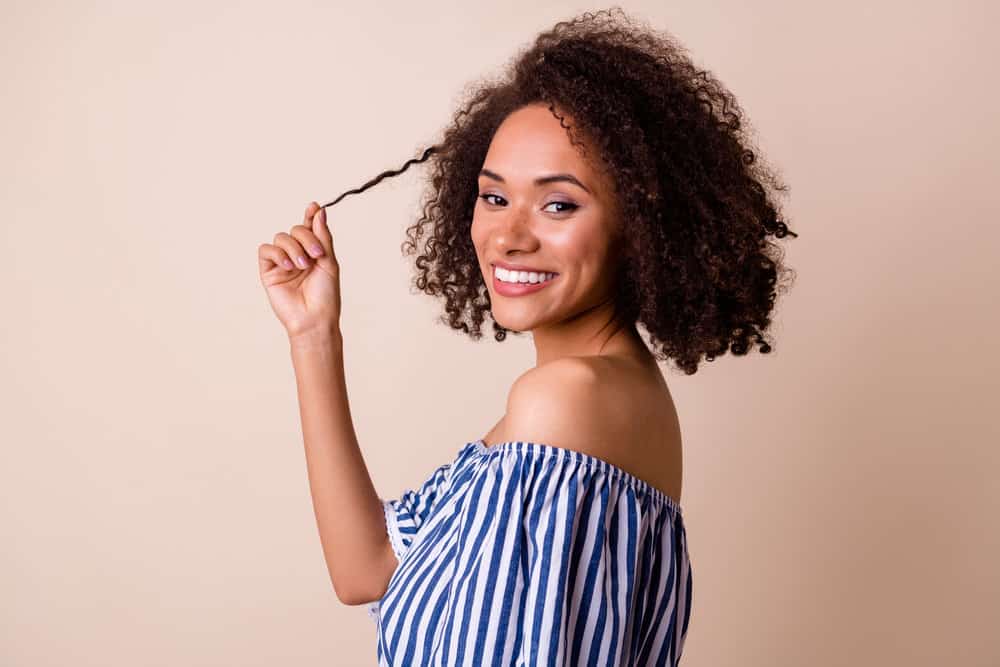 Black lady that used a 10 volume developer and box dye for covering grey hair is showing off hair fiber.