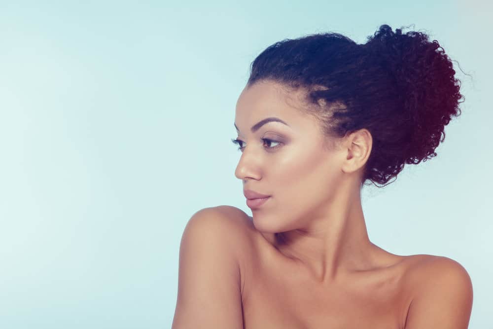 A young black girl with scalp and other hair problems around the nape of the neck.