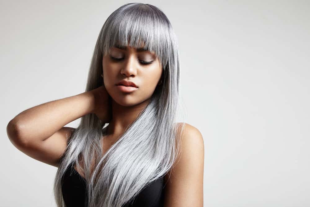 A black woman wearing a gray wig with silver strands after leaving the Great Clips hair salon for highlights and lowlights.