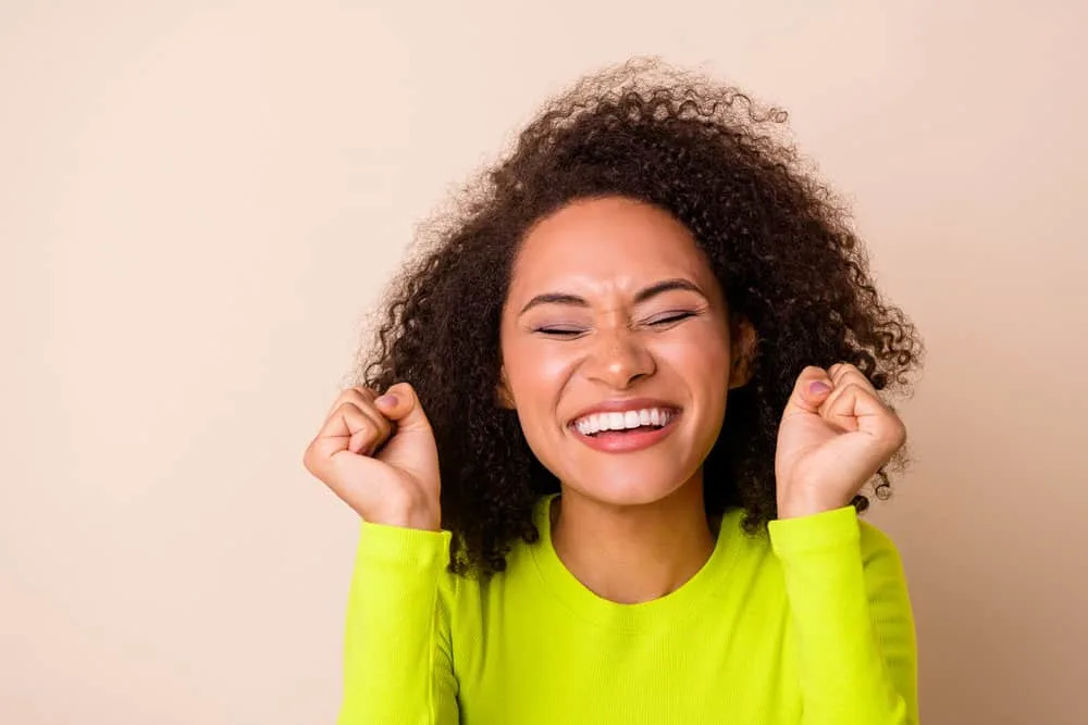 Is Love Beauty and Planet Good for Hair Care? Hair Growth? 11 A young female with natural-looking makeup and curly hair styled with a natural haircare brand.