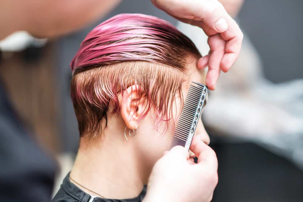 White lady with hair dye stains on the right-side of her neck that was removed with a makeup remover pad.