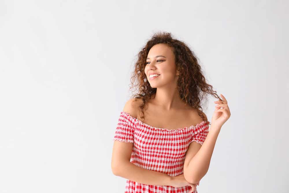 A light-skinned black girl with spiral curls has been embracing her natural texture to minimize heat styling.