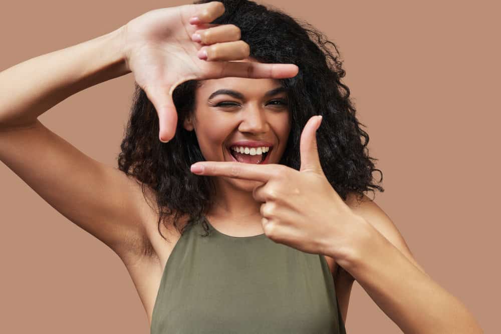 A cute black lady posing for a fun photo after leaving the hair stylist to take a braided protective style.