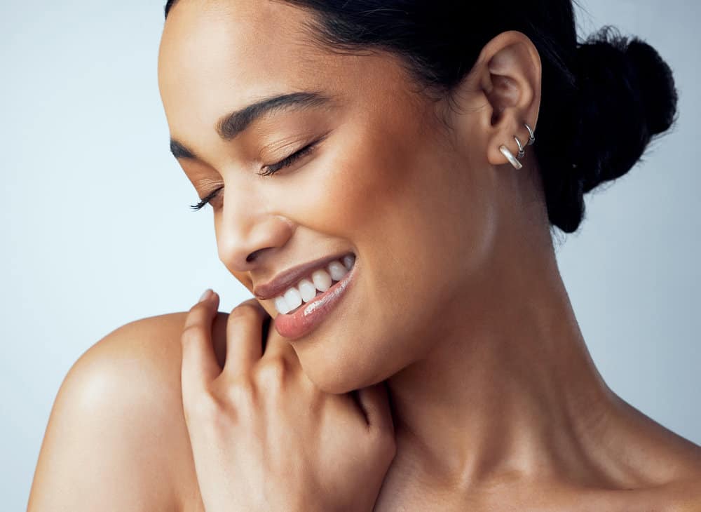 An African American lady wearing her longer hair in a ponytail updo secured by hair clips.