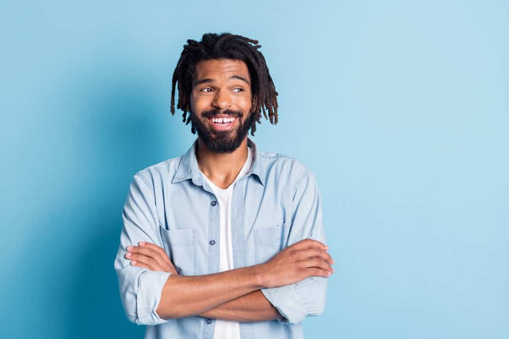 A black guy with super-maintained dreadlocks in an oval face shape that reminds us of the Rastafari movement.