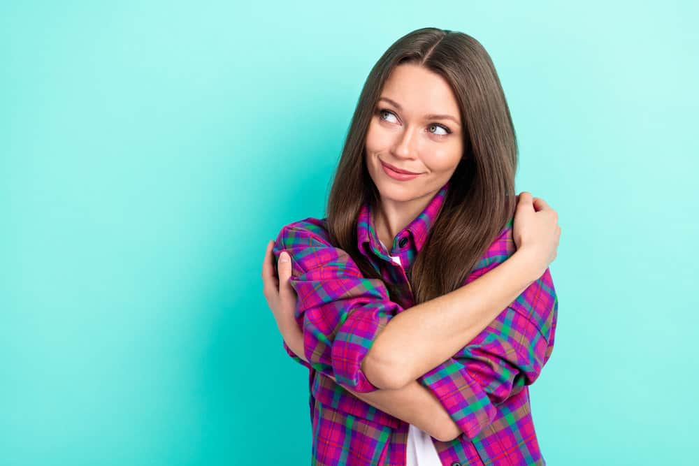 A lady with wavy hair allows her natural volume to shine by wearing her perfectly tousled 1C hair type.