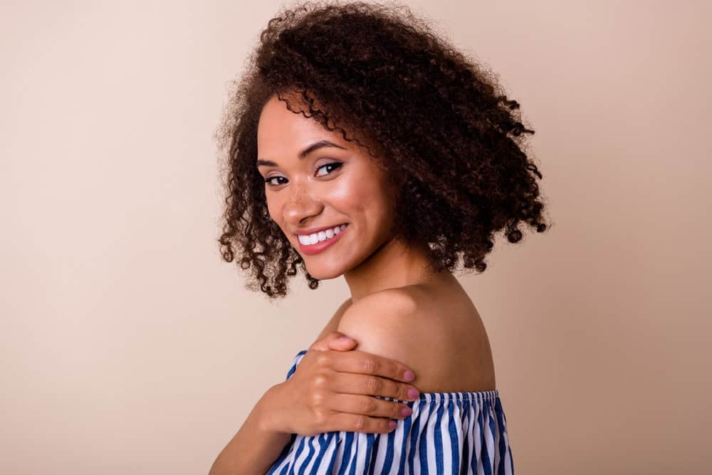 Young African American female with dark brown dyed hair using a dark dye with hydrogen peroxide.