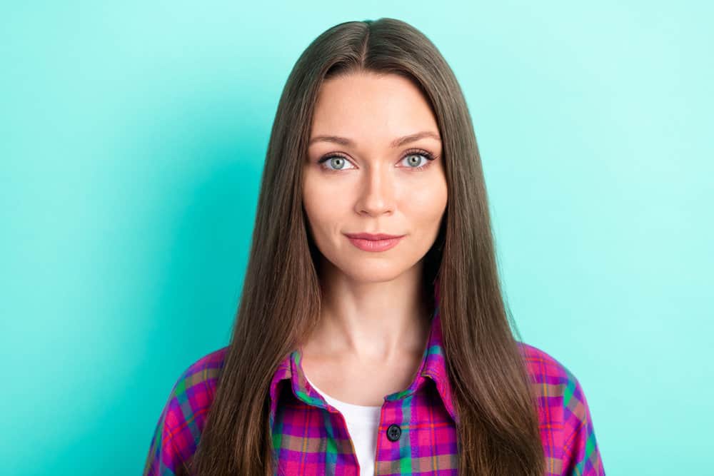 An attractive lady with dry hair posing for a photo after using heat styling tools to dry her wet hair.