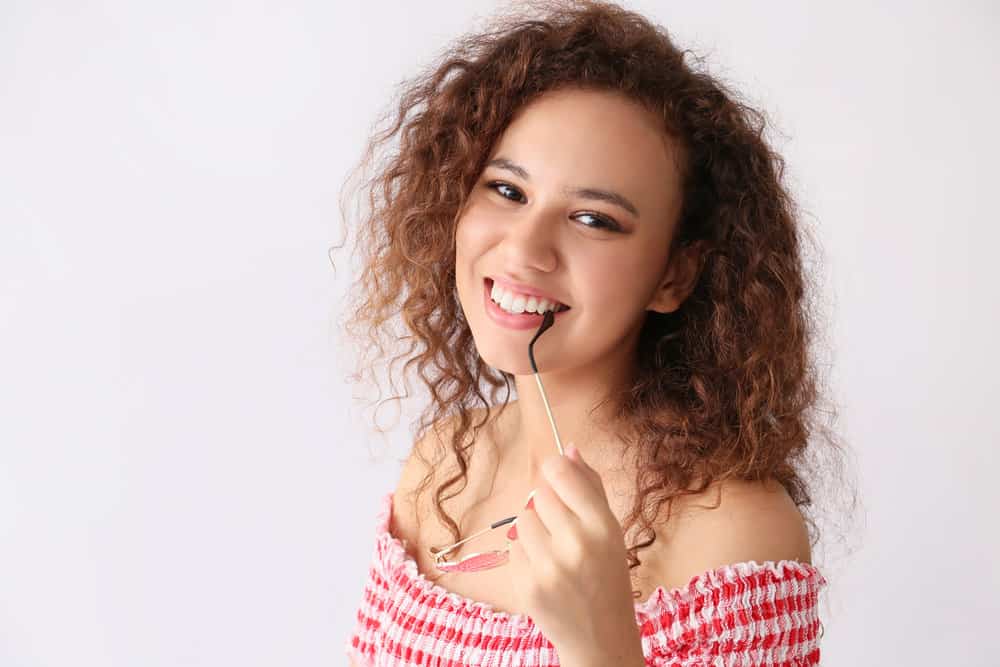 A black girl with naturally curly hair showing off her 3B curl pattern with a style that highlights her natural hair texture.