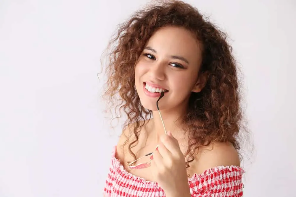 What Is 3B Hair? How To Take Care of It, Styles, and Products 1 A black girl with naturally curly hair showing off her 3B curl pattern with a style that highlights her natural hair texture.