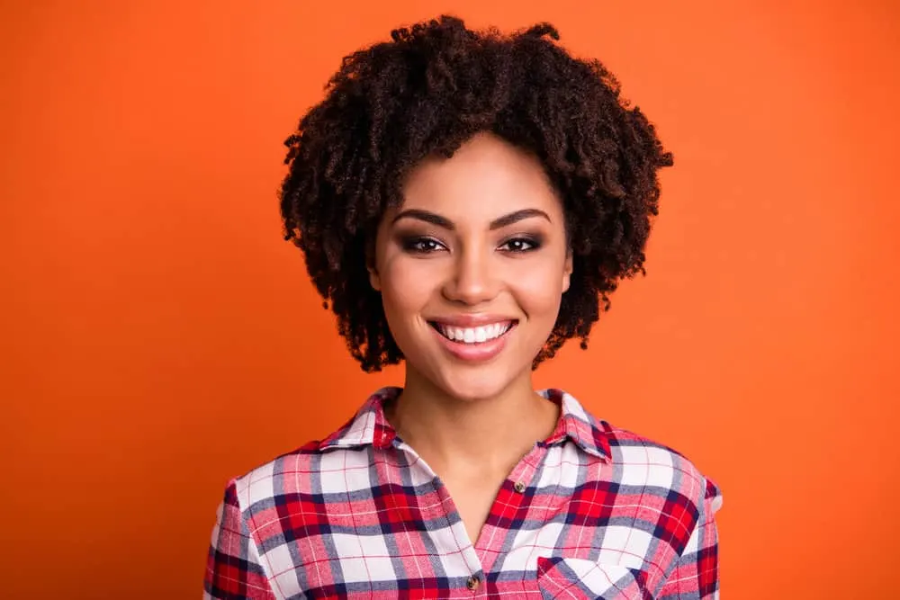 Why Your Hair Grows Outwards Not Down and How to Style It 1 Lovely black female with curly hair follicles on 4C kinky hair strands styled with natural oils to encourage hair growth.
