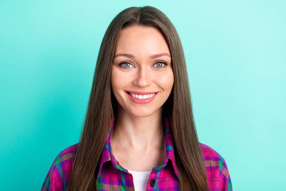 A millennial female with frizzy hair on a 1C straight hair type styled with natural oils and a moisturizing hair mask.