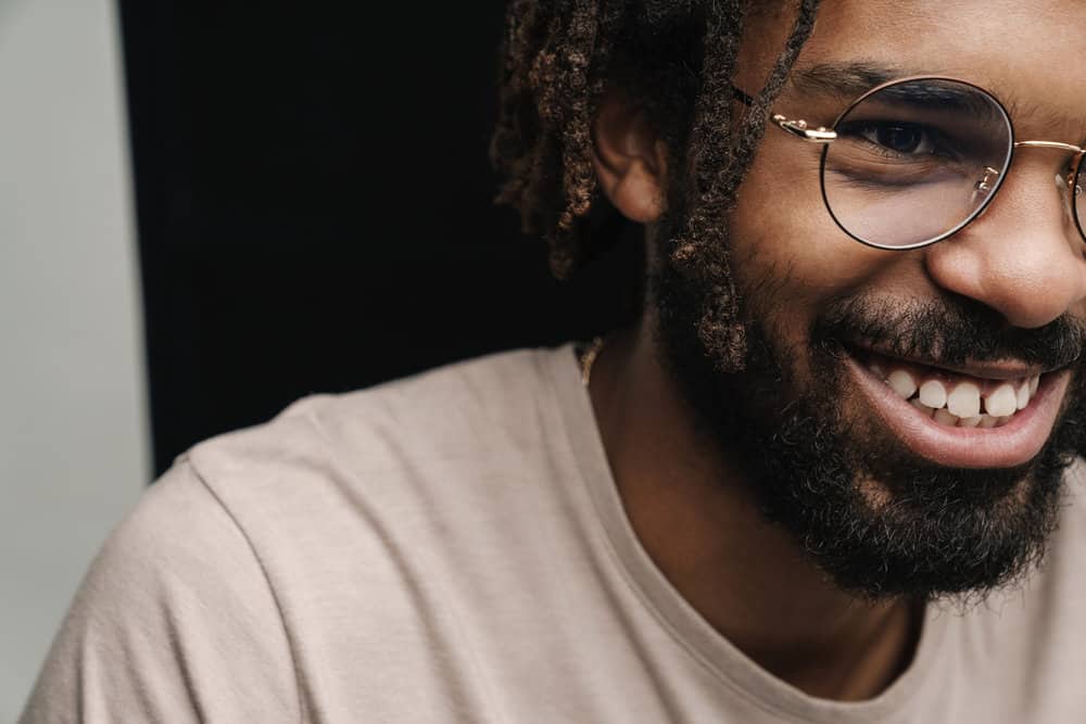 A man that keeps his locs healthy by using a homemade DIY moisturizing spray that includes avocado oil and rose water.