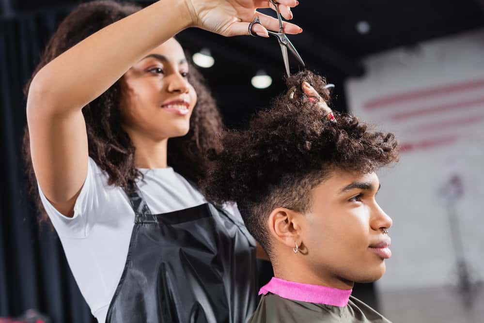 A black man that was seeking a free or discounted trim visits national salons periodically to get a cheap haircut.