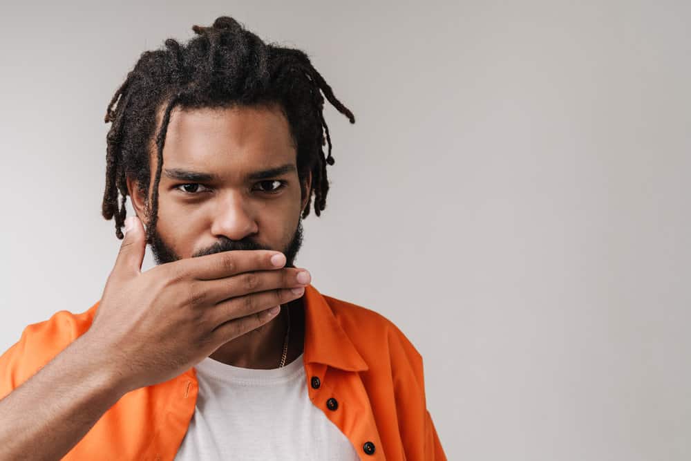 A black man with his hair grouped in the back with rubber bands hoping that policy changes allow soldiers to wear this style. 