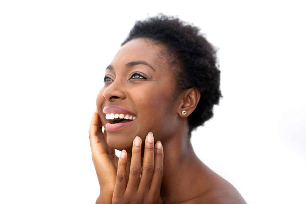 A young black girl with a kinky hair type has hair strand damage heated tools on her high porosity curls.