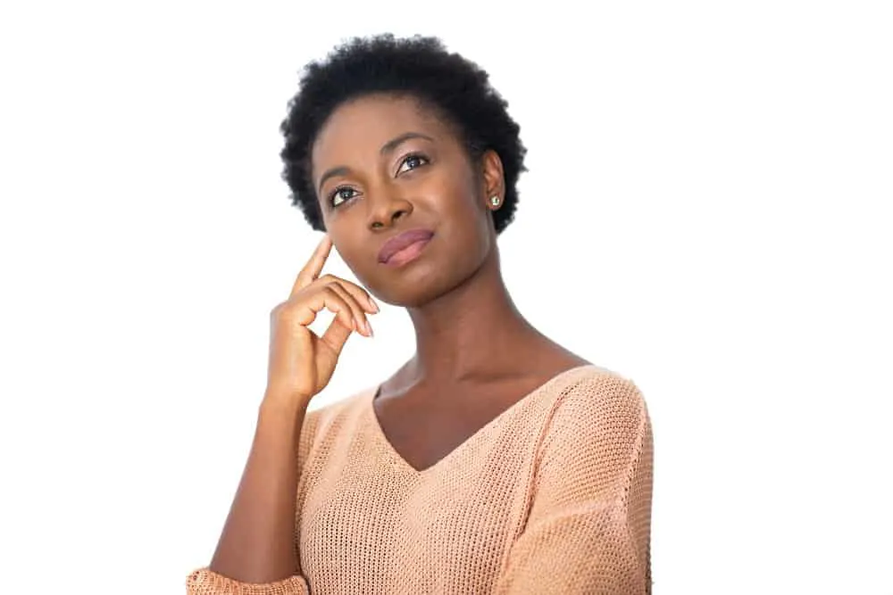 What Is 4C Hair? How To Take Care of It, Styles, and Products 6 A black woman with dry hair that has a Z-shaped curl pattern styled with natural oils, castor oil, and jojoba oil.