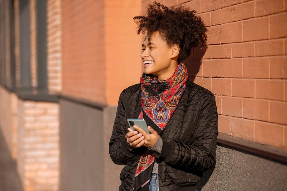 A pretty woman with high porosity hair rocking tight curls is representing the curly community wearing perm rods.