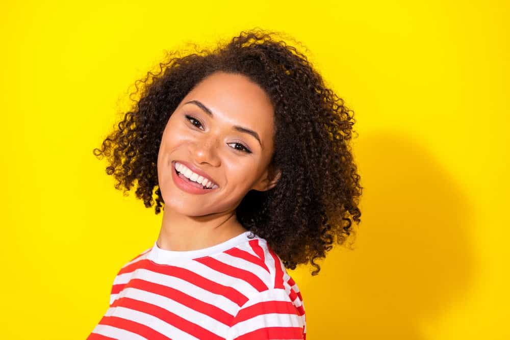 Light-skinned African American female with naturally curly hair strands styled with a texturizing spray that smells good.