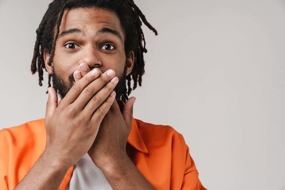 A surprised young black guy wearing "proper wear" for a civilian, although the dreadlocks might not be permitted.