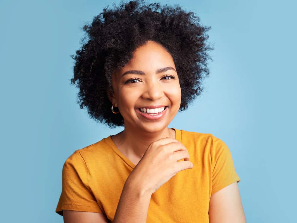 A black girl used a shampoo that made her hair dry and subsequently used hair spray and hair wax to increase moisture levels.