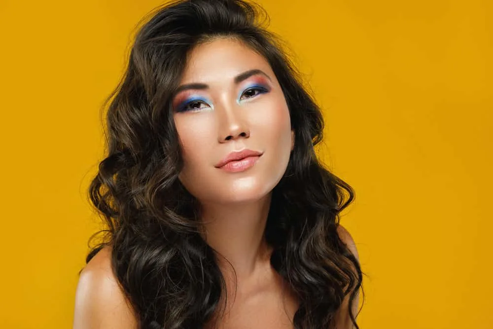 23 Best Hairstyles for Asian Women With Short, Medium & Long Hair 25 A woman with medium length hair wearing a gorgeous hairstyle with side-swept bangs on dark roots.