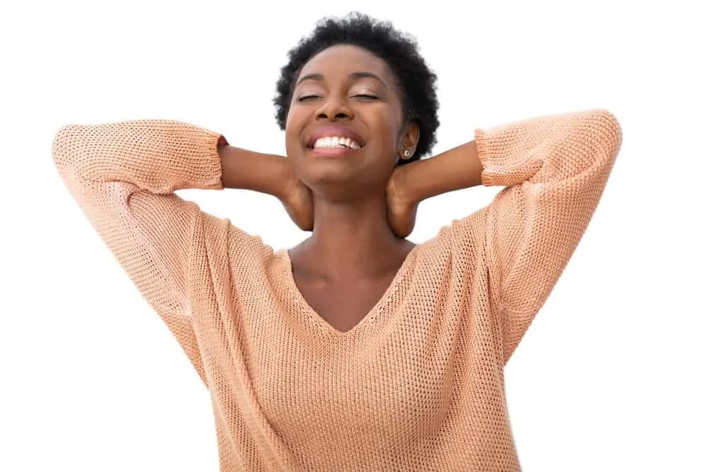 What Is 4C Hair? How To Take Care of It, Styles, and Products 7 A cute African American female with a definite curl pattern showing off her natural texture with a low haircut.