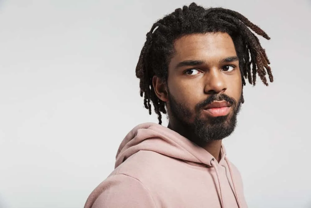 How Much Do Starter Locs Cost? Should You DIY Starter Locs? 3 A black man with mature dreads started with comb coils and has been maintaining his locs with palm rolls.