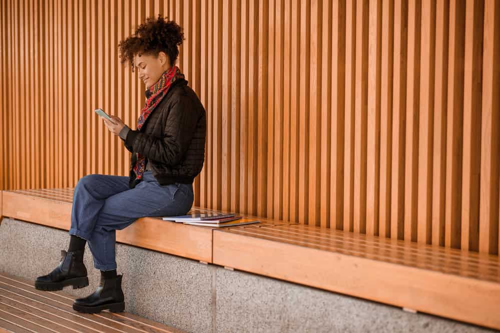 A light-skinned young woman wearing casual clothes researching type 3 curl patterns at a local library.