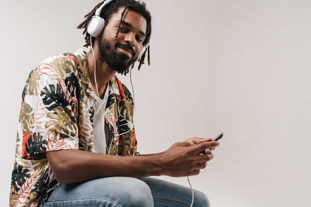 An African American man with thicker locs has used several methods to maintain his dry hair.