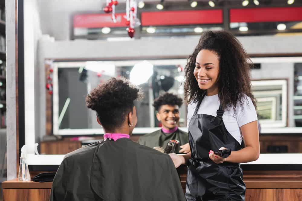 A black man with natural curls getting a good haircut and hair dye service at Regis Salons in Hoover, Alabama.
