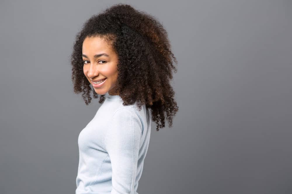 A female with dark brown natural curls washed her hair with baby soap as a gentle Curly Girl-friendly cleaner.