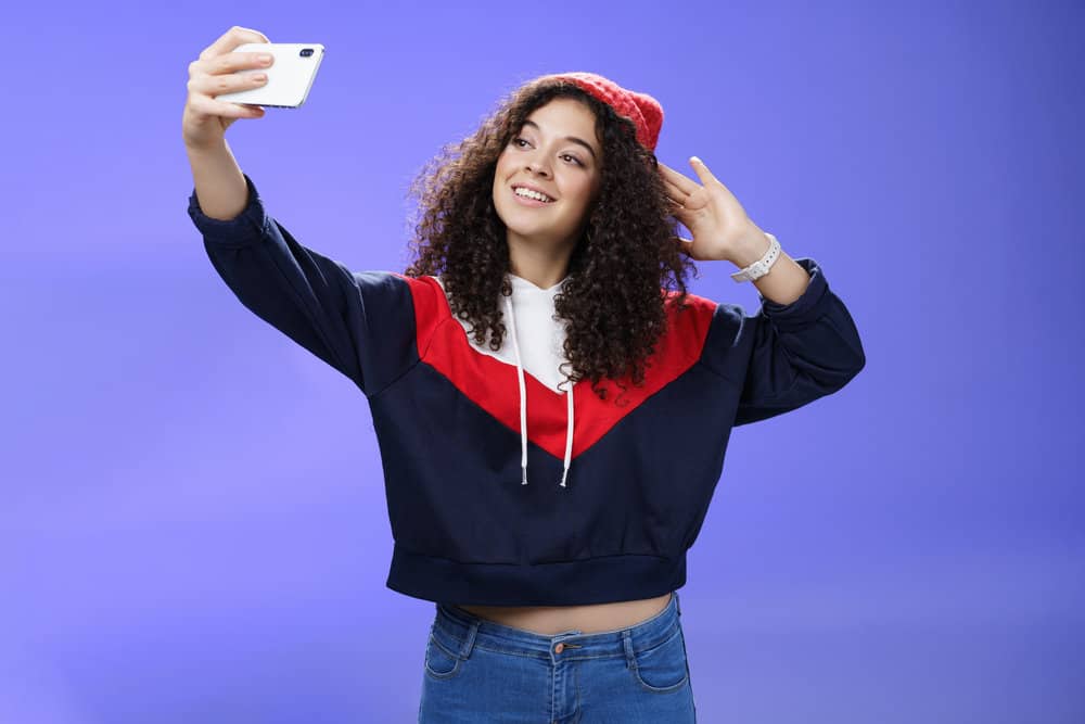 A cute girl that suffered from female pattern hair loss took a selfie of her naturally wavy hair strands.