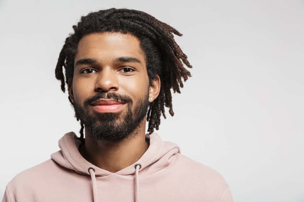 Light-skinned black man with extremely dense hair styled in wool dreadlocks and treated with natural oils.