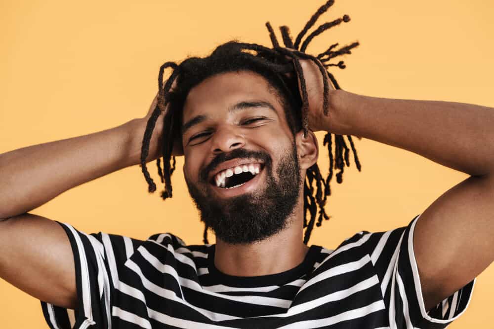 A young black male with healthy dreadlocks wondering how often you have to wash dreadlocks on a 4B hair type.