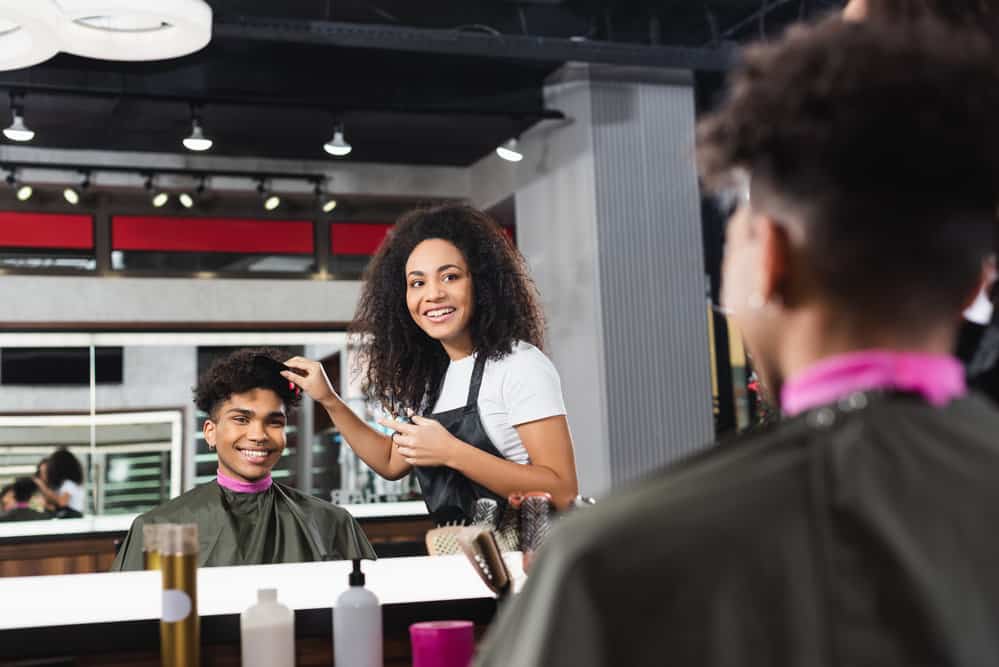 A black man that just got his hair washed by a local barber has a low-maintenance hairstyle.