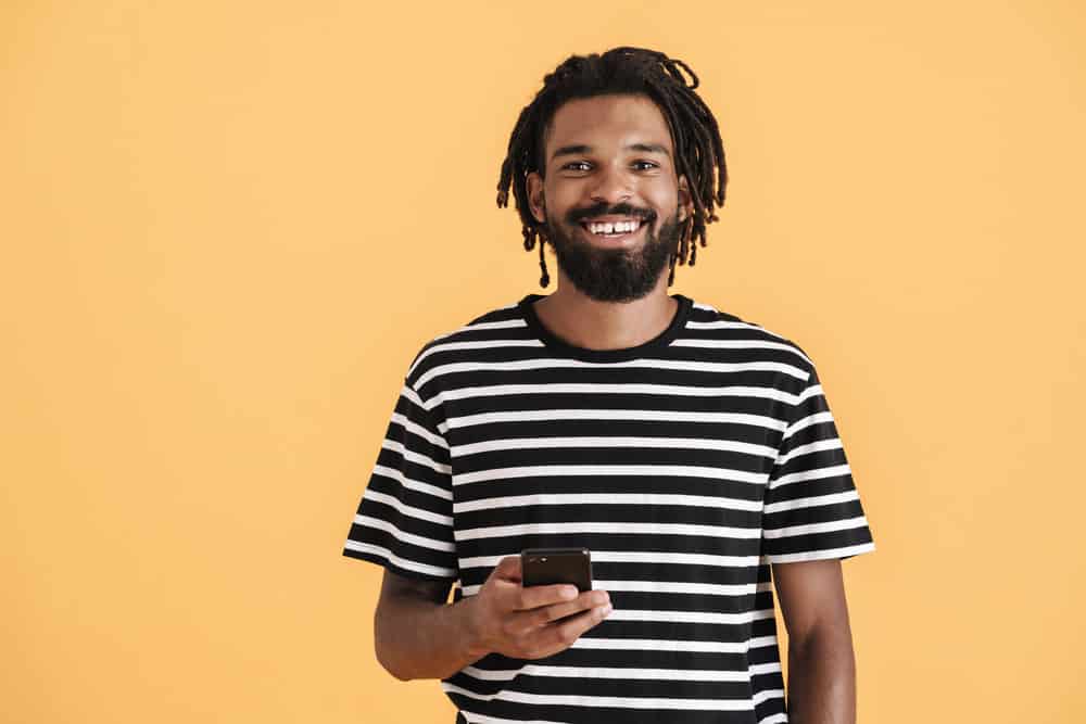 A black guy researching how to wear natural hair and keep it clean, removing excess oil without frequent washing.