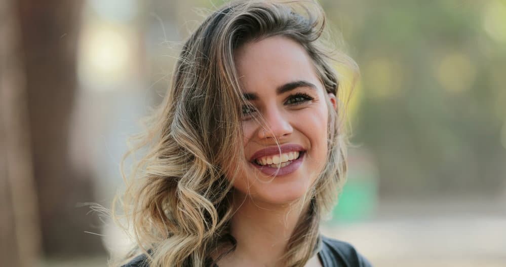 A pretty young female blending gray hair with dark hair using a combination of light gray hair highlights and lowlights.