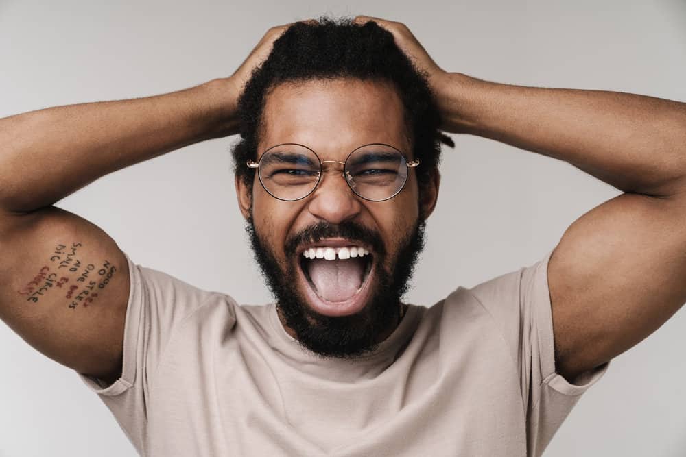 African American man with natural hair has dry locs after overwashing them multiple times per week.