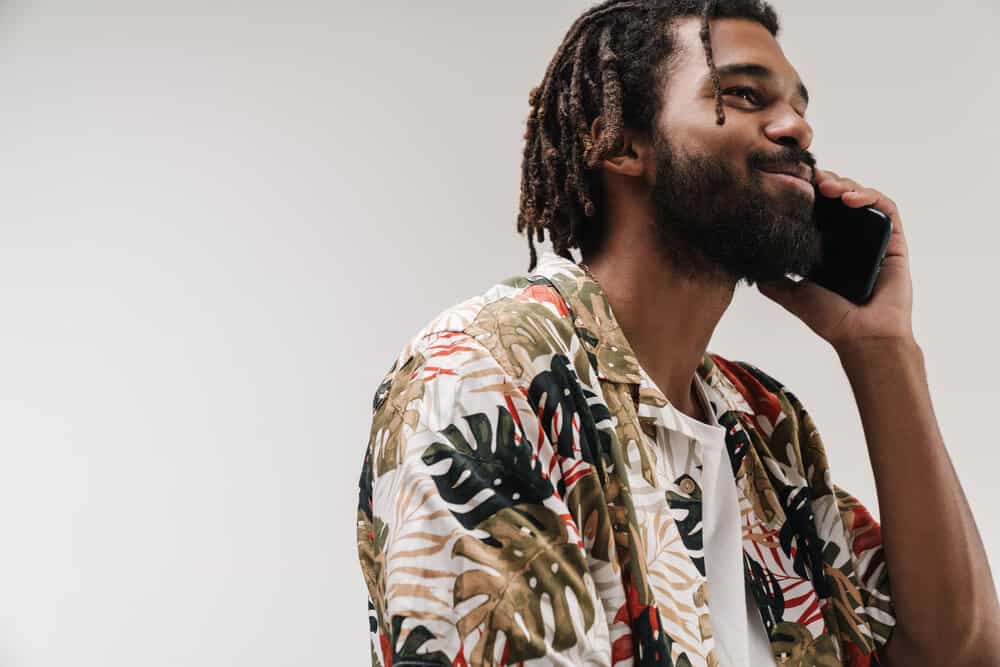 An optimistic African man with thinner locs that were originally created from the two-strand twist method.