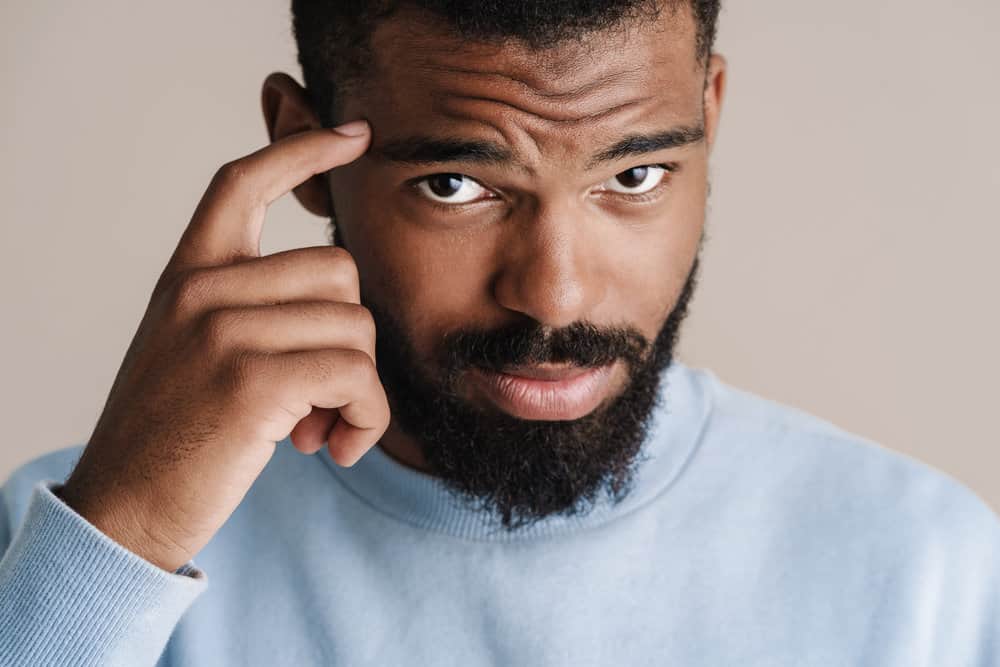 A curious young black male with matted hair gets regular salon hydration treatments to keep his mature locs moisturized.