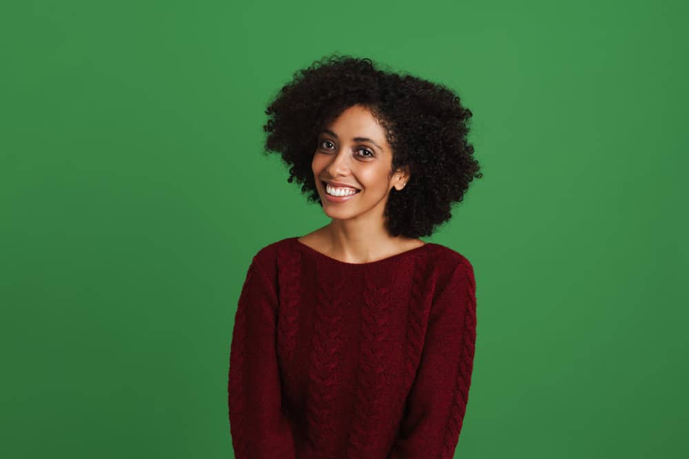 A black female with a damaged hair shaft due to protein buildup on her low porosity hair strands.