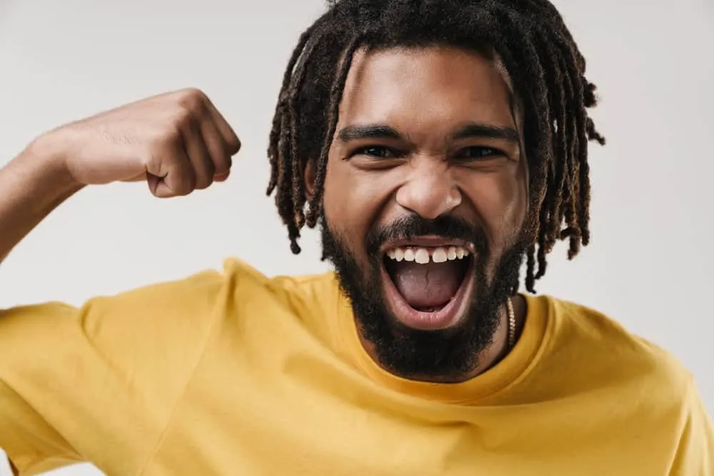 How to Maintain Semi-Freeform Locs: Step-By-Step DIY Guide 5 A happy young black man lets his hair breathe while allowing his locs to grow organically.