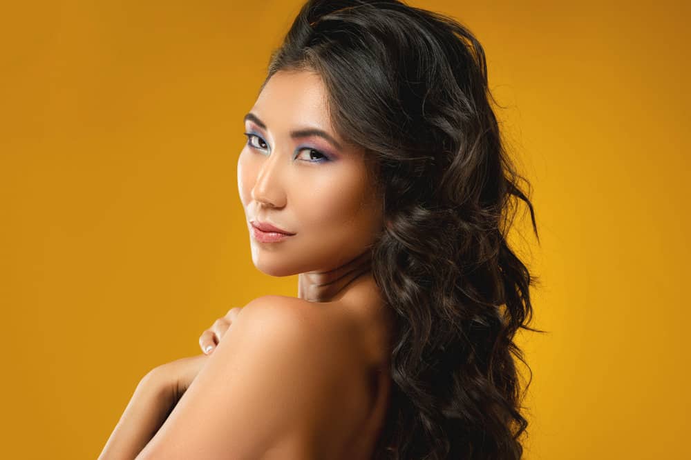 A lady wearing one of the most iconic Asian girl hairstyles on her dark brown naturally thick hair strands.