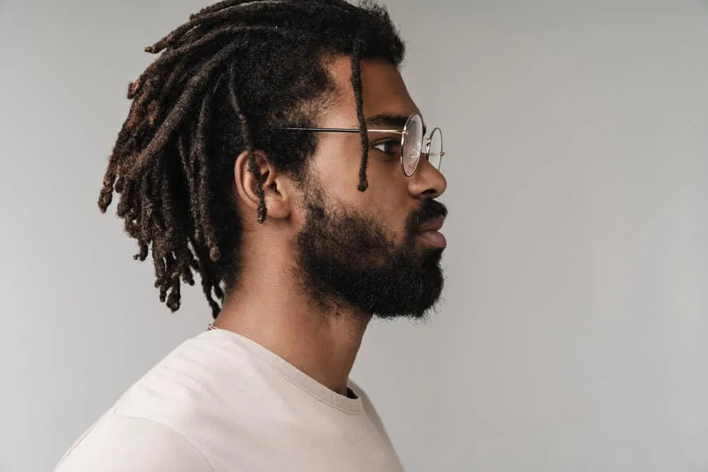 How to Moisturize Starter Locs and What to Use to Hydrate Locs 7 Side view of a serious black male that stores his hair oil with water in a convenient spray bottle to moisturize locs.