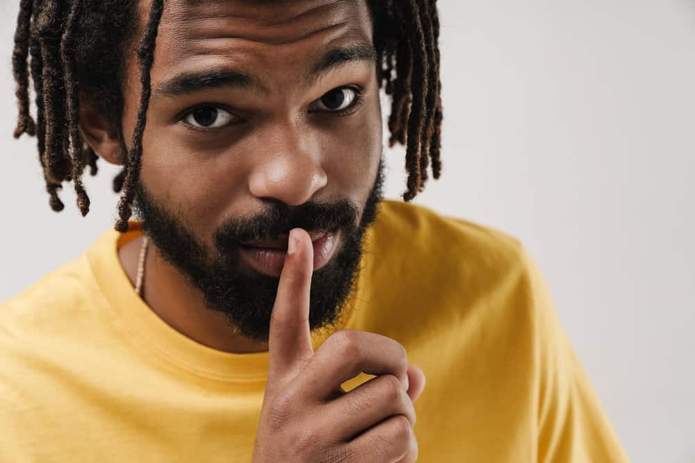 A positive African male with a looser curl pattern washes his hair regularly to remove product buildup.